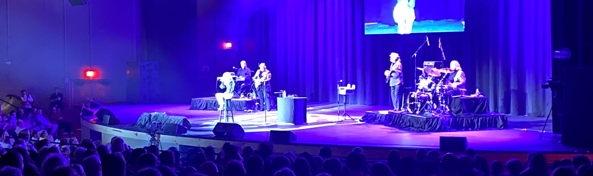 signer on stage in chair washed out by the lights Greensboro